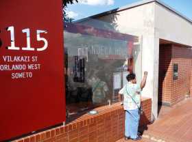 Afrique du Sud Johannesburg Soweto Apatheid prix Nobel de la paix Mandela Tutu Le poing levé devant la maison de Mandela, beaucoup de visiteurs, métis, noirs ou blancs se font photographier