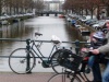 reflets argentés sur les canaux et passage furtif des vélos à Amsterdam en Hollande